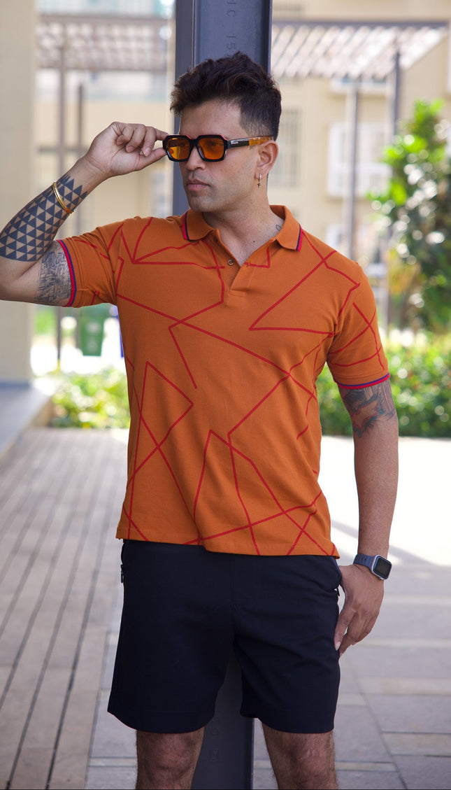 Man wearing an orange patterned polo shirt and black shorts outdoors.