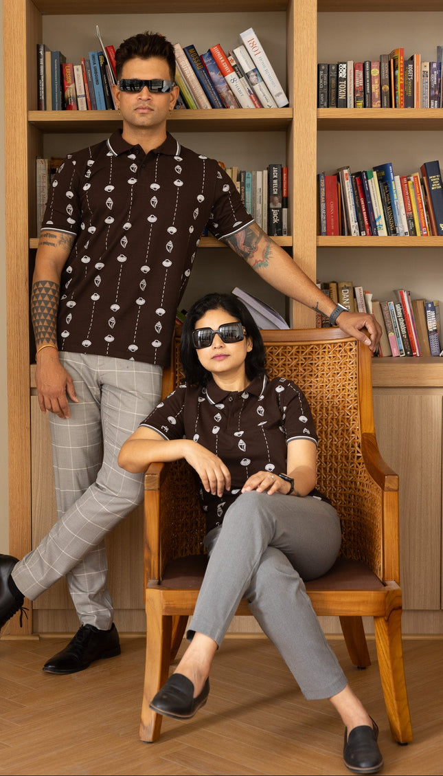 Two people posing in front of a bookshelf filled with books.
