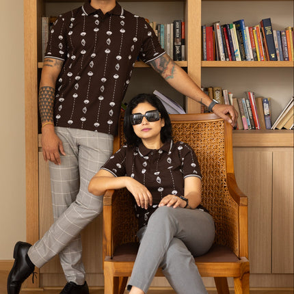 Two people posing in front of a bookshelf filled with books.