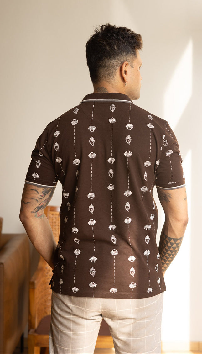 Man wearing a patterned brown shirt in an indoor setting
