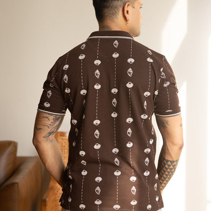 Man wearing a patterned brown shirt in an indoor setting