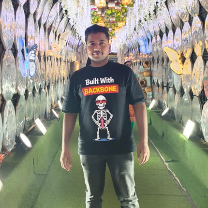 Man Wearing a RREFLEKT T-Shirt standing in a decorated tunnel with lights and flowers