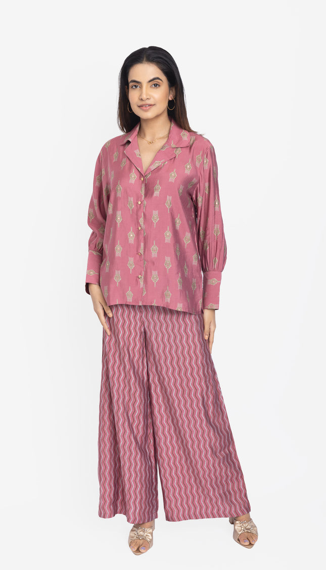 Woman wearing a pink pajama set with a white background