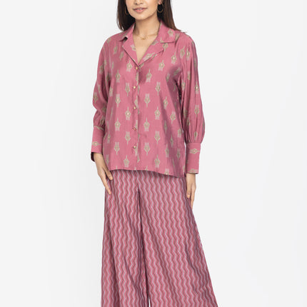 Woman wearing a pink pajama set with a white background