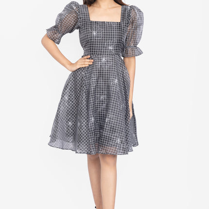 Woman wearing a checkered dress with puff sleeves