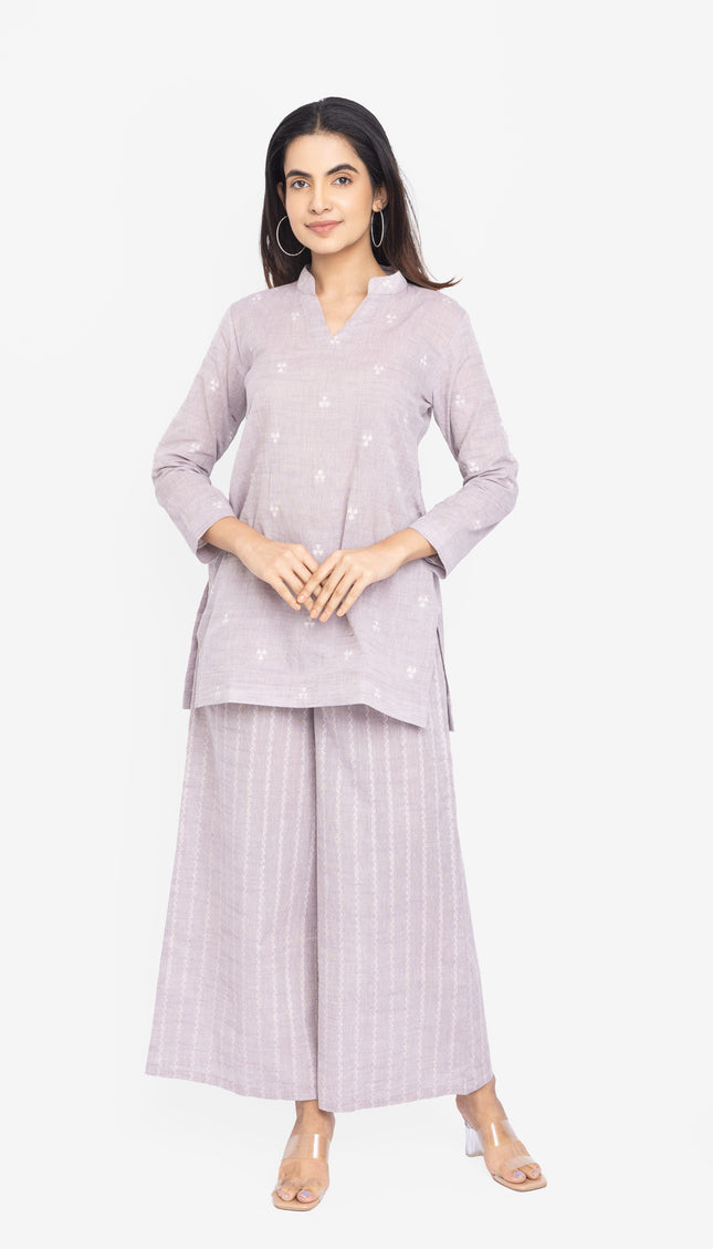 Woman wearing a light purple outfit with a matching top and wide-leg pants