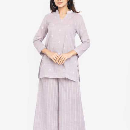 Woman wearing a light purple outfit with a matching top and wide-leg pants
