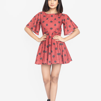 Woman wearing a red dress with black polka dots