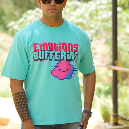 Person wearing a teal t-shirt with 'Emotions Buffering' graphic outdoors.