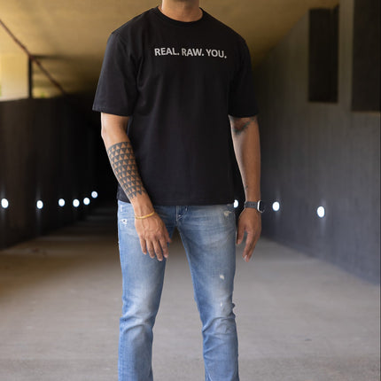 Man wearing a black t-shirt with text and sunglasses in an indoor setting