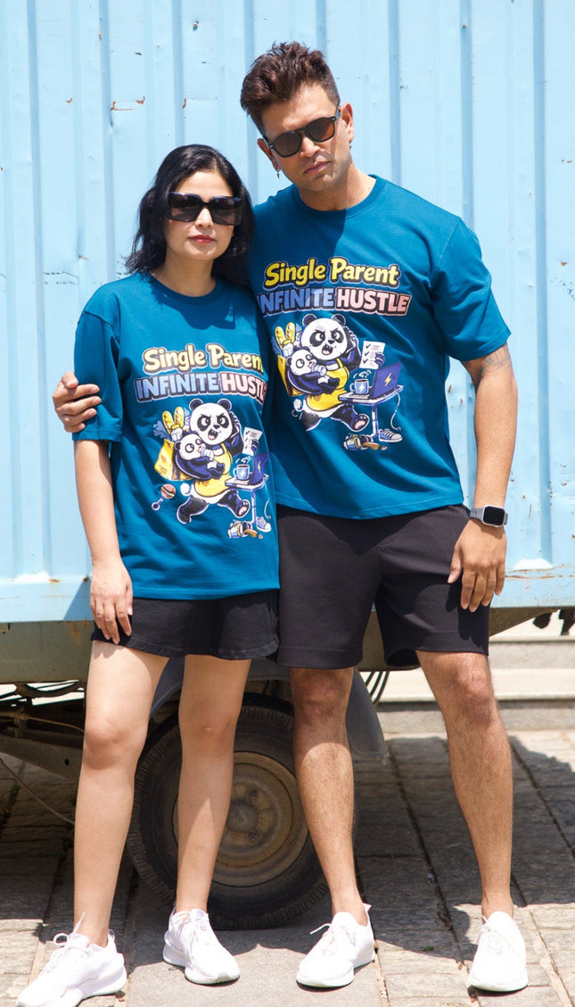 Two people wearing matching blue t-shirts with cartoon characters in front of a blue shipping container.