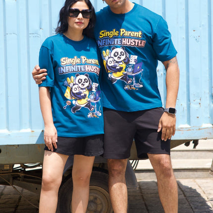 Two people wearing matching blue t-shirts with cartoon characters in front of a blue shipping container.