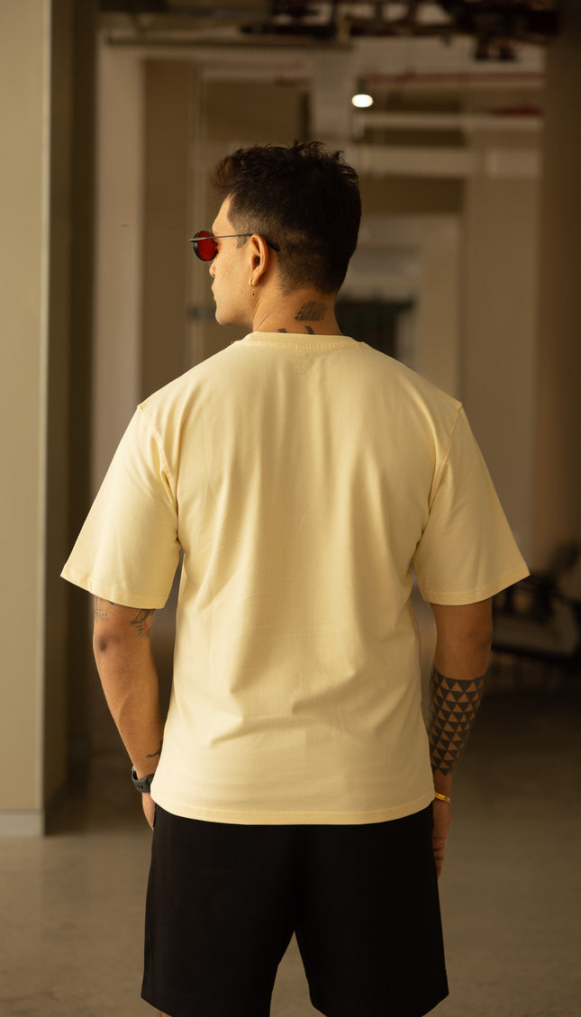 Man wearing a beige t-shirt and black shorts in an indoor setting