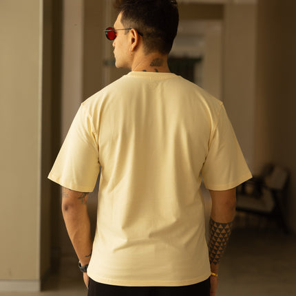 Man wearing a beige t-shirt and black shorts in an indoor setting