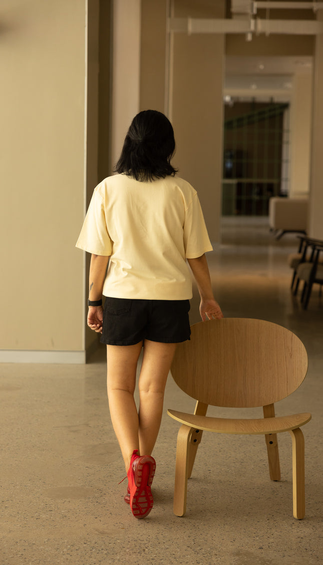 Woman wearing beige t-shirt and standing 