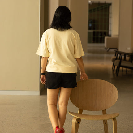 Woman wearing beige t-shirt and standing 
